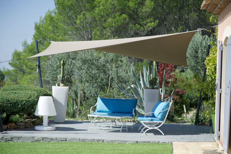 Shade cloth covering a seating area in a backyard