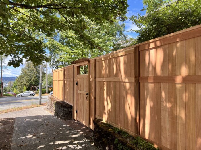 Wood soundproof fence with street view and cars in the background